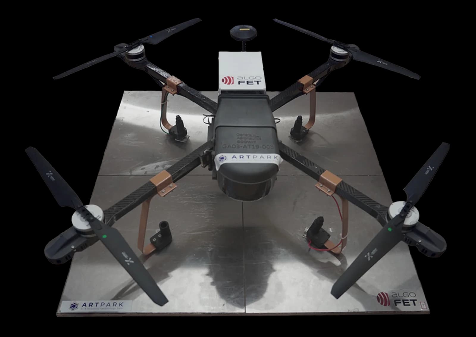 Quadcopter with contact landing gear resting on an AlgoPAD charging plate
